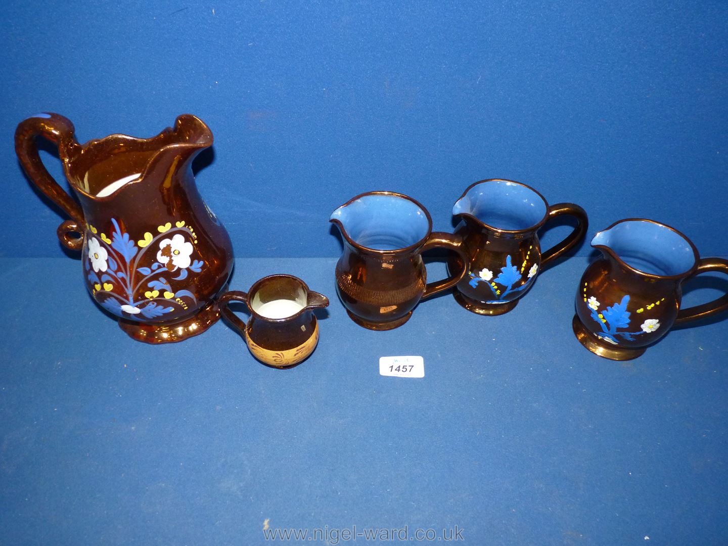Five lustre jugs in various sizes and patterns including three hand painted with blue/white and
