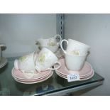 A Wedgwood Susie Cooper part Teaset with white flag Iris design and pink borders to include;