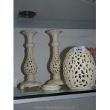 A pair of modern openwork candlesticks and night light in cream colour.