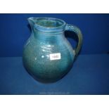 A large blue Studio pottery jug by Gisela Hunting, with a ribbed handle, 11" tall x 9" wide.