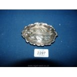 A small oval white metal pin dish in the ford of three oak leaves with three acorns,