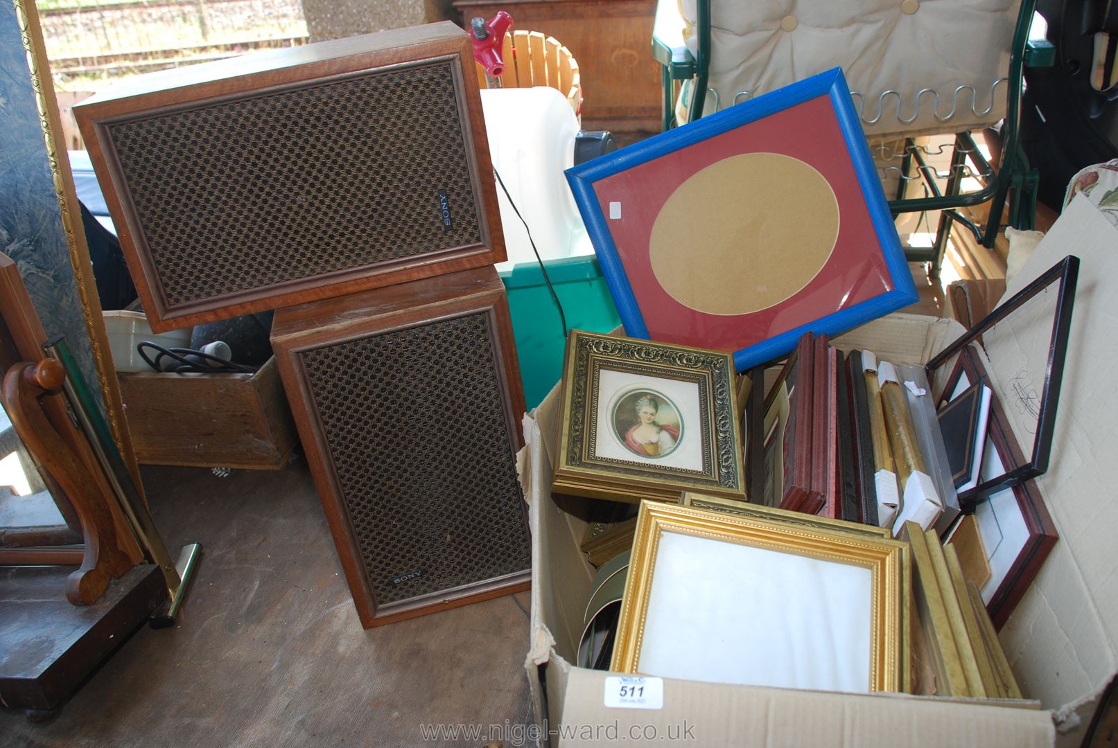 Two wooden Sony speakers and a large box of various picture frames, etc.