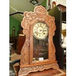 A mantle clock carved surround having floral motif and scrolling, complete with key and pendulum,