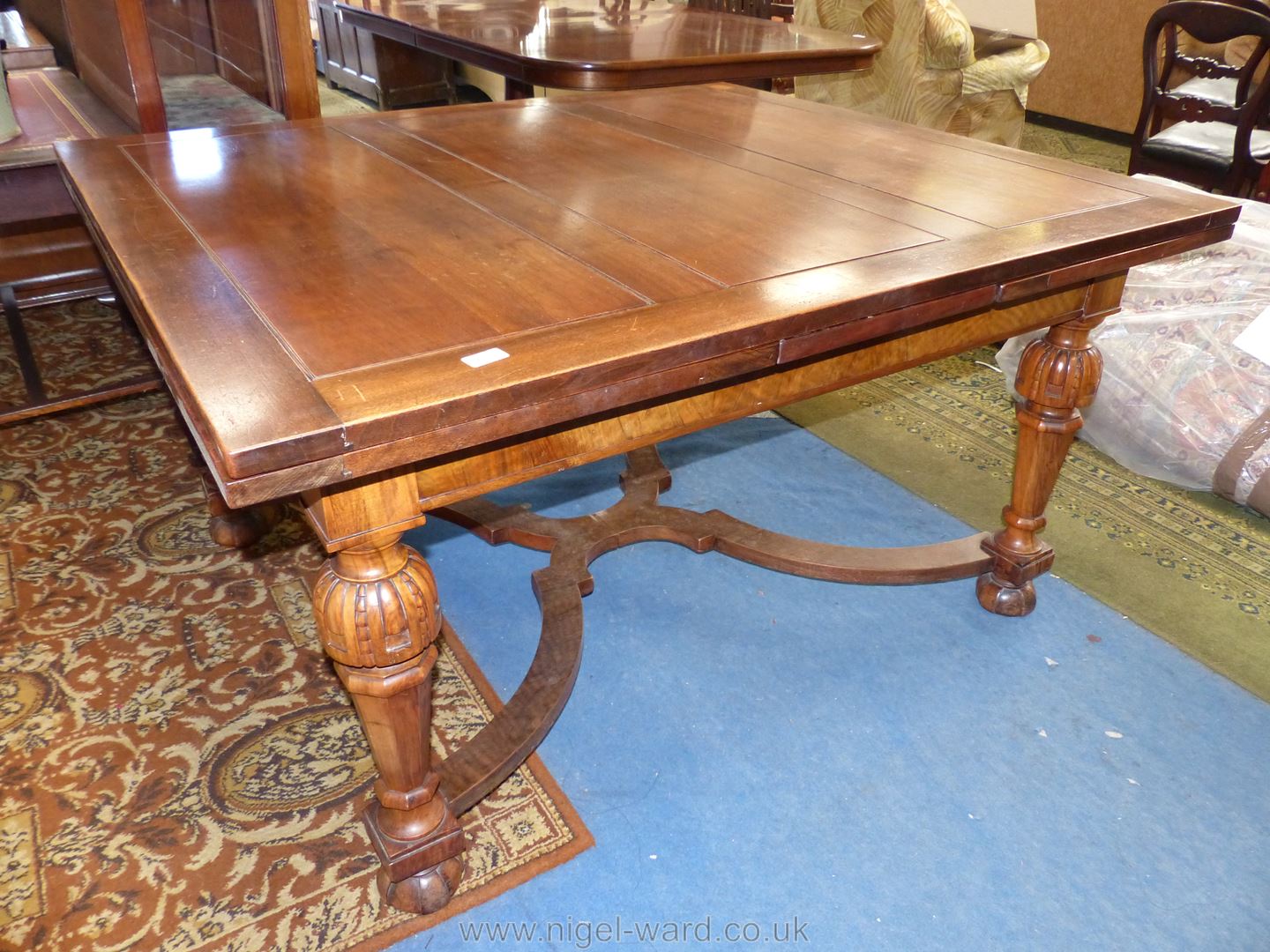 A Mahogany and Walnut draw leaf Dining Table standing on turned and tapering eight sided legs with