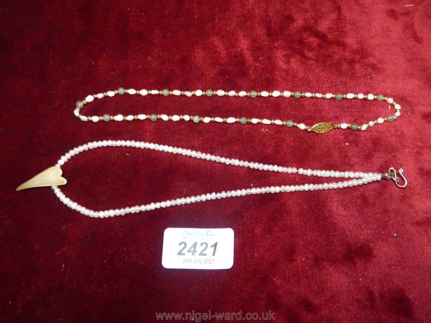 Two dainty necklaces, possibly seed pearls.