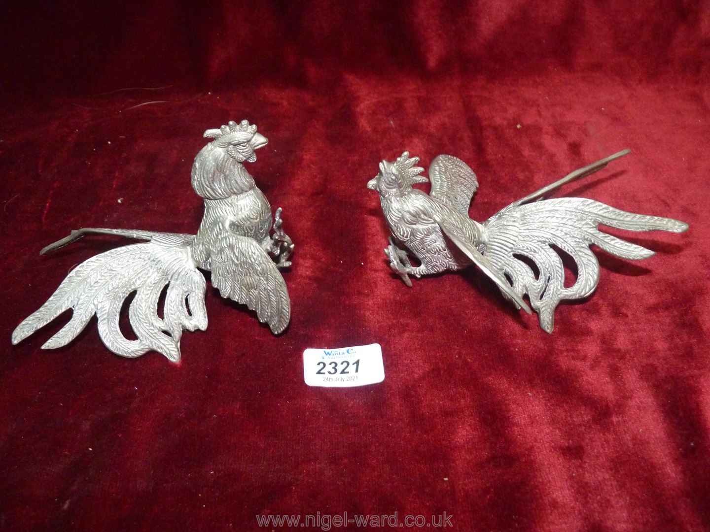 Two white metal fighting cocks figures.