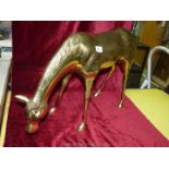 A large brass figure of a horse, 30'' wide x 17'' tall.