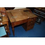Pitch pine clerks desk with double inkwell and four drawer pedestal.