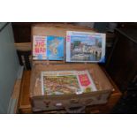 Canvas suitcase and three jigsaws.