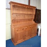 A Pine dresser with three drawers and cupboard base and plate rack over, 71'' x 79'' x 21'' deep.