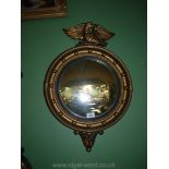 A 1930's gilt convex Mirror with eagle finial, 24" long.