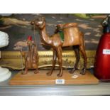 A carved wooden figure of man leading a Camel, 16" x 12" tall.