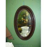 A darkwood framed oval bevel plated wall Mirror,