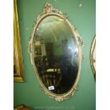 A cream painted carved wood framed oval bevel plated wall Mirror, 26'' tall, a/f.