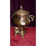 A large copper and brass samovar with turned handles. Some dents.