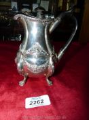 A Silver embossed hot water Jug with claw feet, darkwood handle and finial, Birmingham 1901,