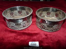 A pair of large silver plate galleried wine Coasters with embossed garland decoration.