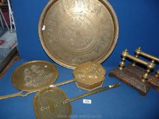 A quantity of brass including chestnut roaster, skimmer, fire iron rests, plaque and charger.