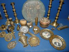 A quantity of brass including Cow bells, candlesticks, charger, horse brasses etc.