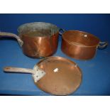 A copper serving dish and copper lid and saucepan.