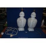 A pair of decorative white ceramic Table Lamps having panels of pierced decoration,