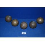 Five brass finished boules.