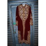 A ruby red velvet Kaftan style robe with gold and silver colour thread embroidered decoration,