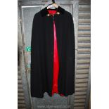 A Gieves & Hawkes of Saville Row, pure new wool black Cape with red viscose lining,