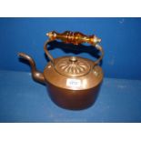 A copper kettle with amber glass handle.
