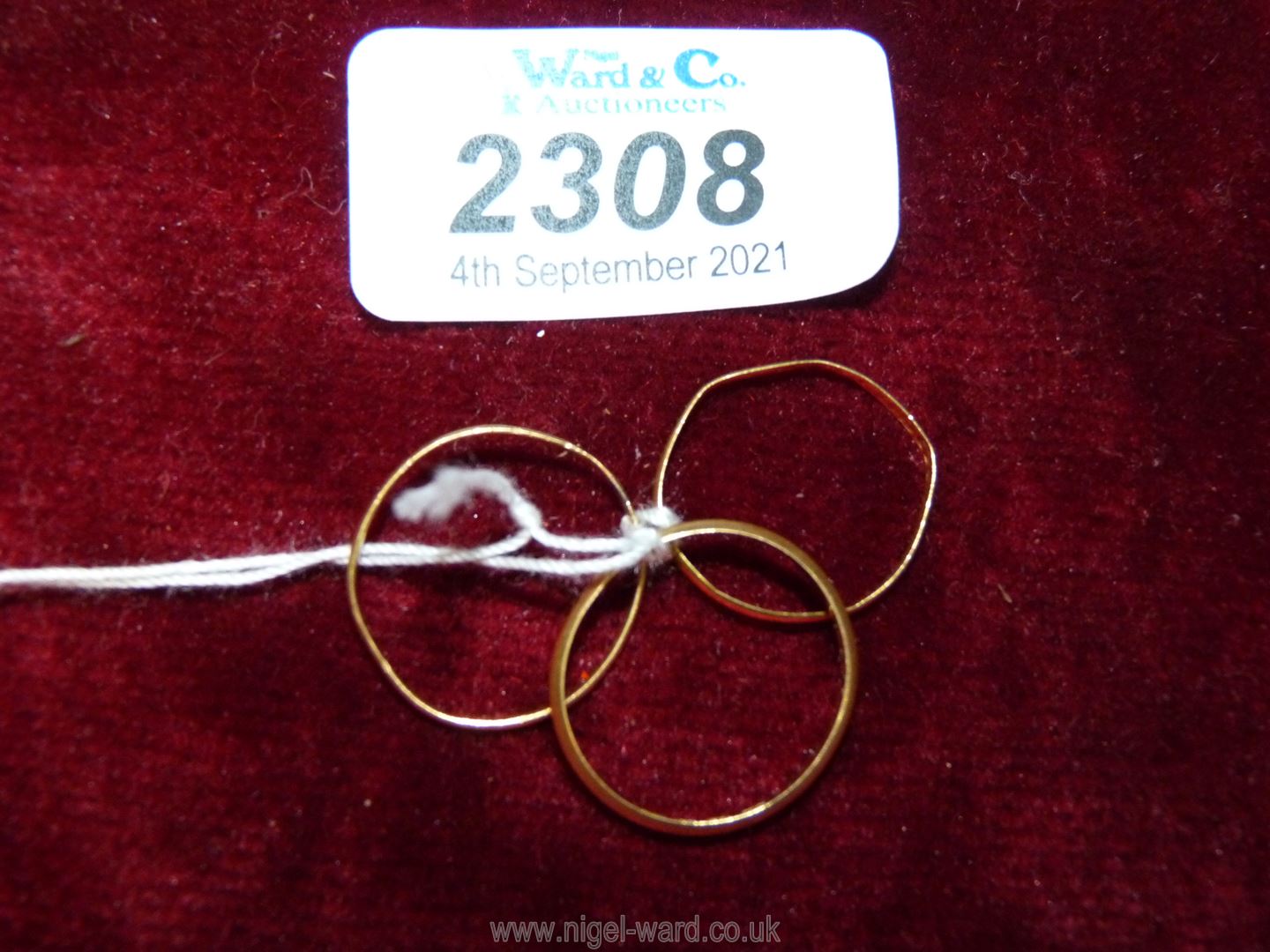 Three thin 22 ct. gold wedding Bands, mis-shaped, one being by JW & Co.