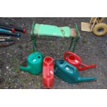 Four watering cans and a garden kneeler.