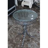 A glass topped and wrought iron table, 17 1/2" diameter, and 25" high.