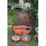 Two plastic corner planters, potted shrub, terracotta pot feet etc.