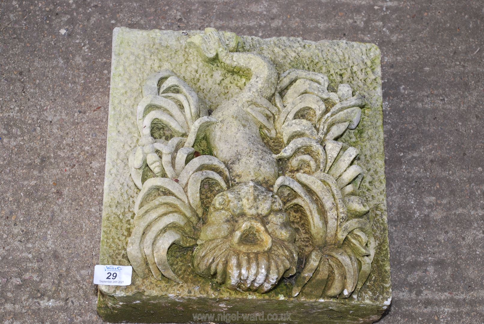 A concrete gargoyle of a stylized fish, 12 1/2" x 12 1/2".