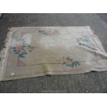 A fringed rug with floral design, stained and worn, 78'' x 54''.