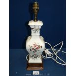 A china lamp base decorated with birds and flowers standing on a wooden base. 15 1/2" tall.
