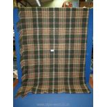 A green tartan wool blanket/throw with fringing. Single size.