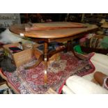 A Mahogany cross-banded topped curved-ended dining table standing on two turned supports with swept