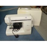 An electric Janome Sewing machine with foot pedal and hard cover.