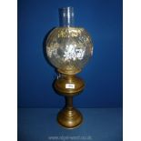 A Victorian oil lamp with clear globe, white with flowers, on brass base with chimney, 23" tall.
