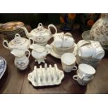 A cream with gilt flower design Teaset including teapot, sucrier, toast rack, twelve cups,