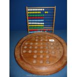 A large wooden Solitaire board and a child's abacus.