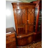 A contemporary Mahogany bow-fronted Display Cabinet above a cupboard base and having cross banding,