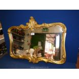 An ornate gilt framed mirror.