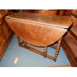 An Oak gate-leg drop-leaf table standing on elegant turned legs,