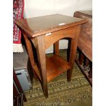 A heavy dark Oak occasional/lamp table standing on tapering square legs united by a lower shelf,