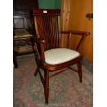 An appealing Mahogany Arts & Crafts open-armed elbow chair standing on turned legs with an "H"