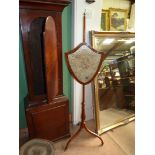 An embroidered shield shape pole screen on three legs, screen a/f., 56" tall.