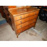 A Walnut finished Chest of four long Drawers with drop handles and standing on brief cabriole legs,
