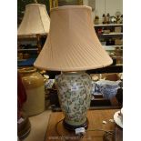 A china table lamp decorated in leaves with a cream shade. 26" tall.